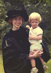 Marye Anne Fox at her Ph.D. graduation in cap and gown, holding her son, Bobby