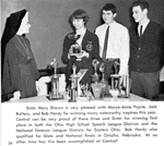 Photograph of Marye-Anne Payne Fox (holding a trophy), Jack Raftery, Bob Hardy, and Sister Mary Shawn.  Caption reads: Sister Mary Shawn is very pleased with Marye-Anne Payne, Jack Raftery, and Bob Hardy for winning many noteworthy trophies this year. Central can be very proud of these three and Sister for winning first place in both the Ohio High School Speech League Districts and the National Forensic League Districts for Eastern Ohio. Bob Hardy also qualified for State and National finals in Omaha, Nebraska. At no other time has this been accomplished at Central!