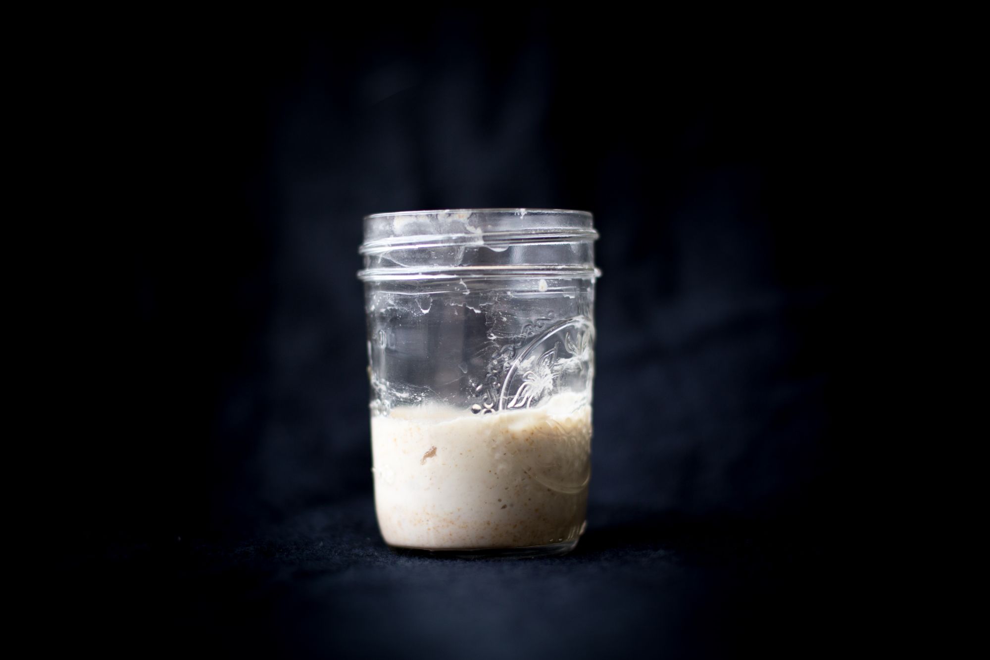 Glass jar containing sourdough starter