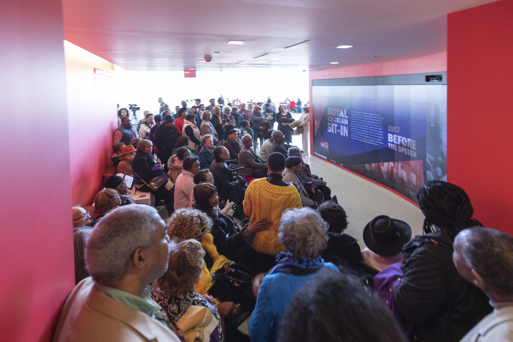 A large crowd in front of a video wall