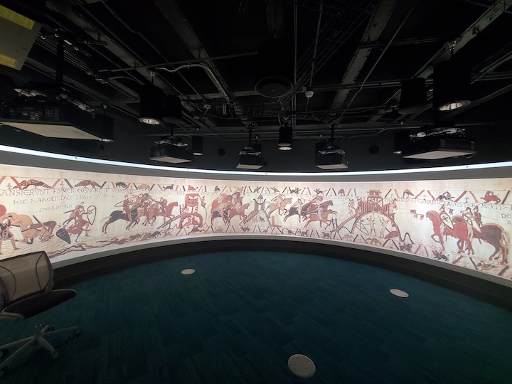 projection of Bayuex tapestry with embroidered horses and shoulders