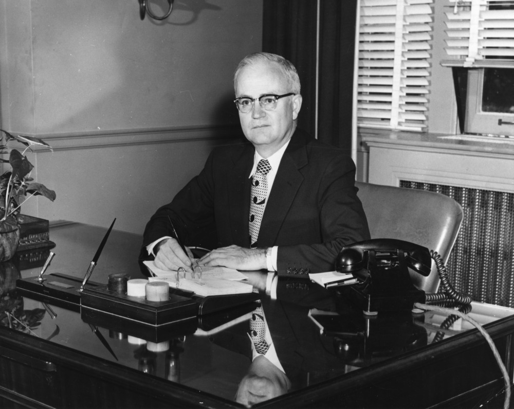 A black and white photograph of Chancellor Carey H. Bostian sitting at his desk.
