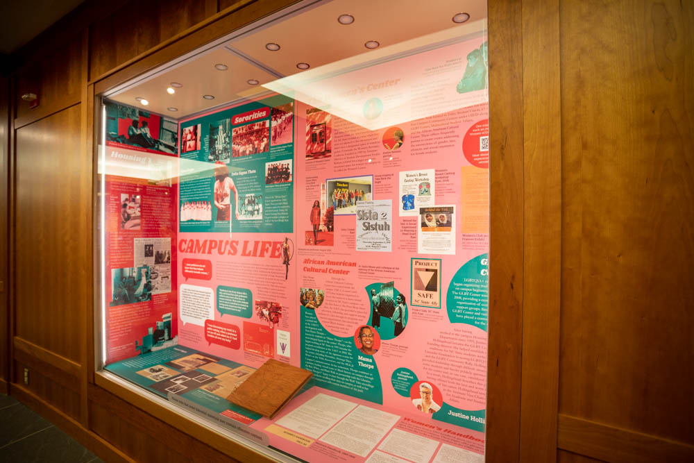 A large display case features the impact women have had on campus life in the history of NC State
