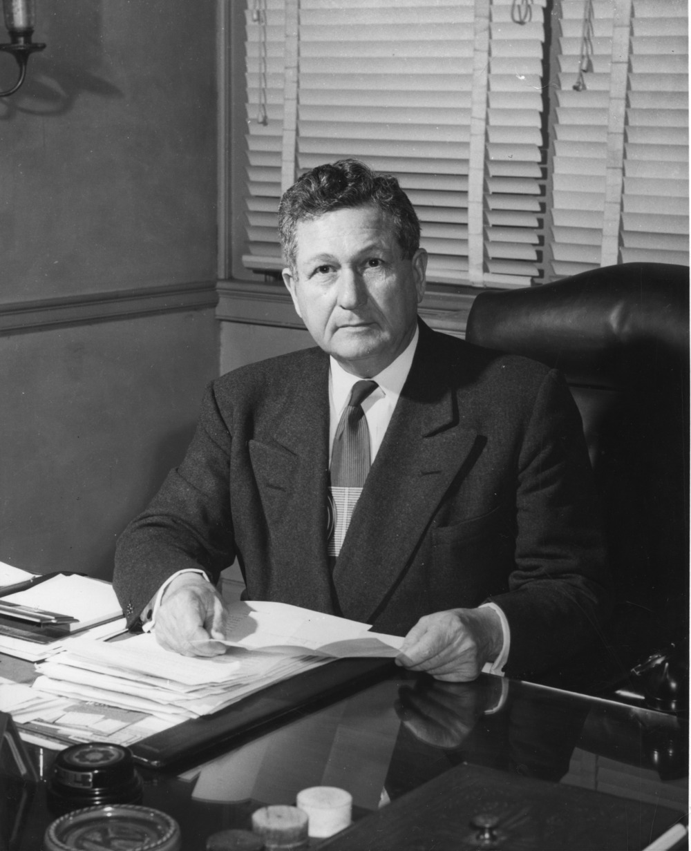 A black and white photograph of Chancellor John W. Harrelson at his desk.