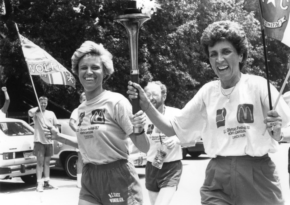 Nora Lynn Finch and Kay Yow carrying United States Olympic Festival Torch through North Carolina State University campus, fall 1987.