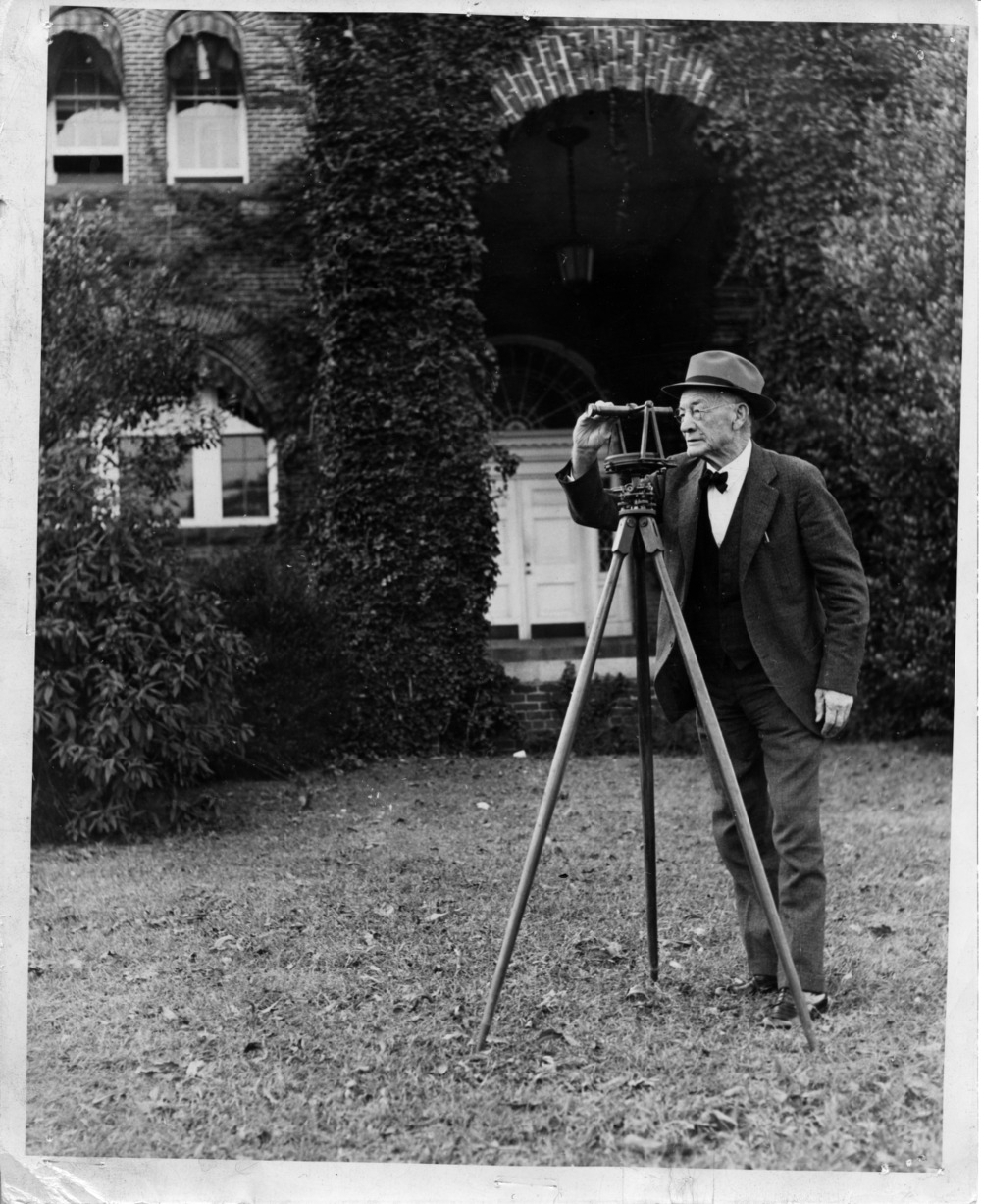 Black and white photograph titled "W. C. Riddick with surveying instrument he had used in the late 1830s to survey the right-of-way for the Raleigh and Gaston Railroad".