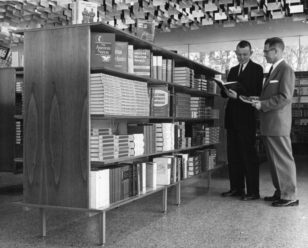     Cyrus B. King (left) and Clement L. Chambers (right) looking at textbooks in newly constructed Student Supply Store, 1960