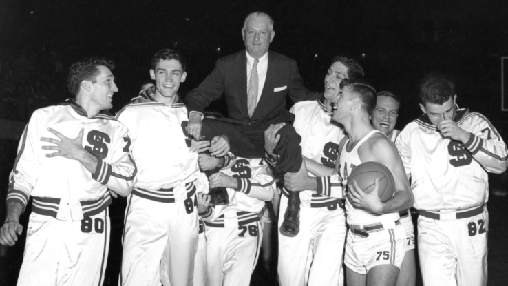 he NC State men’s basketball team lifts coach Everett Case on their shoulders after winning 1955 Atlantic Coast Conference championship.