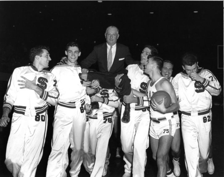 In celebration of winning the 1955 Atlantic Coast Conference championship, Coach Everett Case is lifted onto the NC State men's basketeball team's shoulders