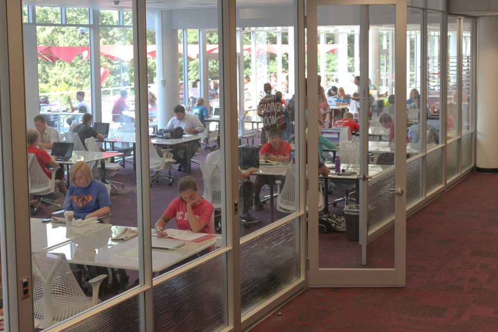Entrance to glassed in area of Hill Library's silent reading room with students working at tables inside.