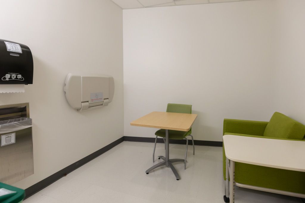 Hunt Library Lactation room with changing table, table, chair, and soft seating.