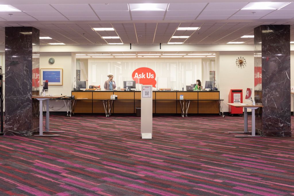 Large open area in front of the Ask Us service desk with columns and kiosk computers.