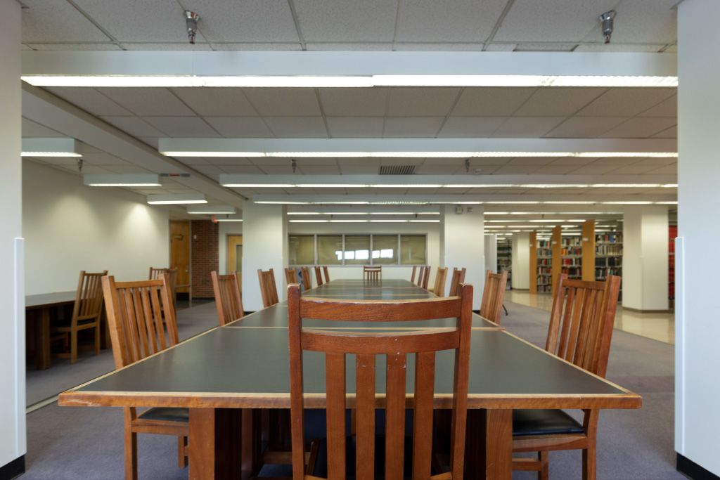 Large tables with upright wood chairs in an open space