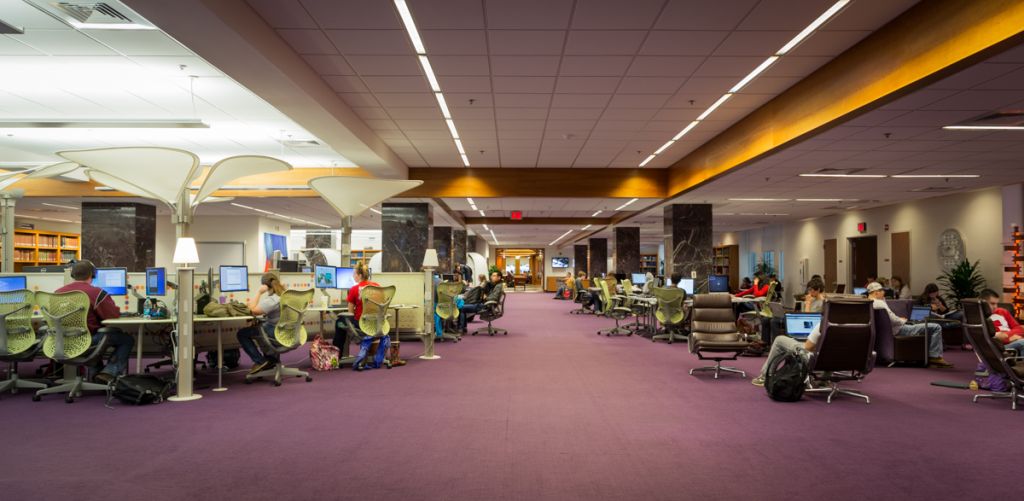 Large space with many desktop computers, office chairs, and lounge seating