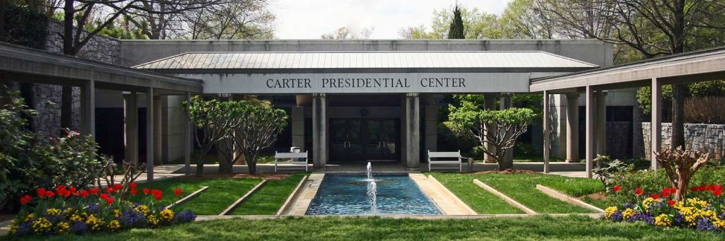 a green garden in front of a building that says "Carter Presidential Center"