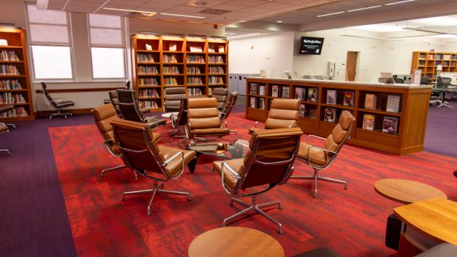 Four lounge chairs surrounded by bookshelves