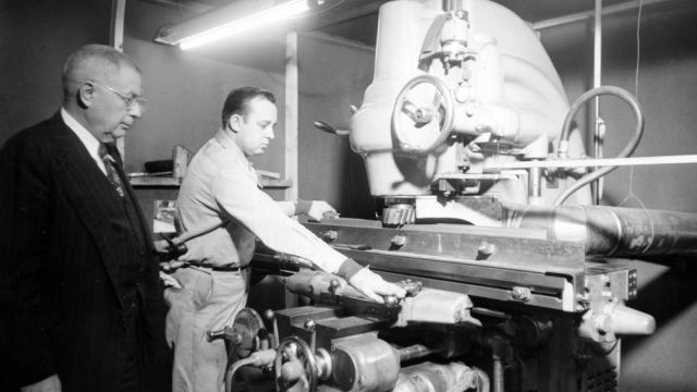 Fred Wheeler, left, supervises grinding graphite for the nuclear reactor, 1951