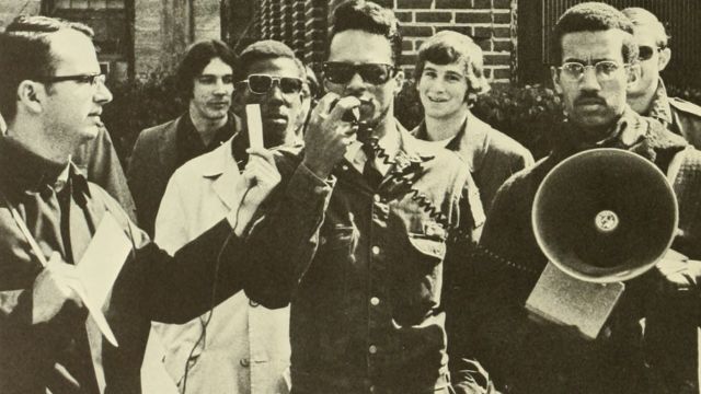 A rally supporting NC State facilities employees, 28 Feb. 1969.  Society of Afro-American Culture President Eric Moore holds the loudspeaker.  Agromeck 1969 photo.