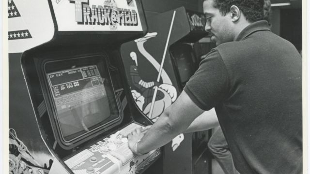 Photo of an NC State student playing the popular arcade game, Track and Field (circa 1984).