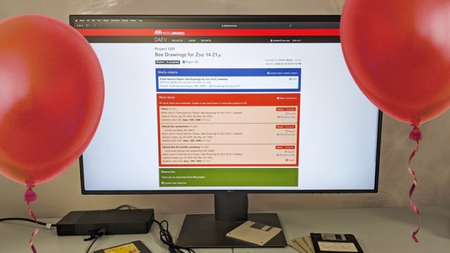 DAEV 2 on computer monitor, floppy disks, two red balloons