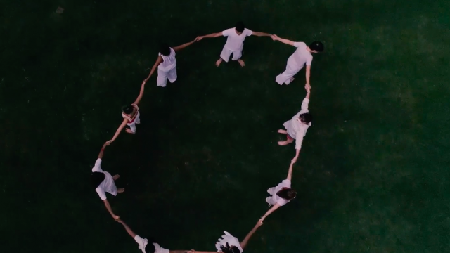 A still image of dancers in a circle, as seen from above, from a dance video by choreographer Killian Manning.