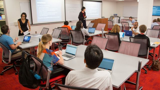 Mentors guide students through computer application tutorial.