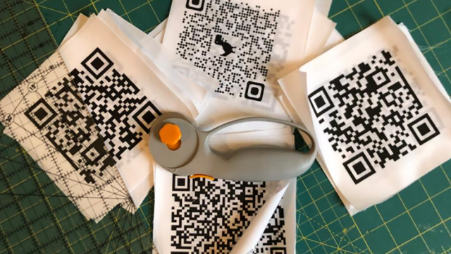 Fabric patches with printed QR codes, arranged with a rotary cutter