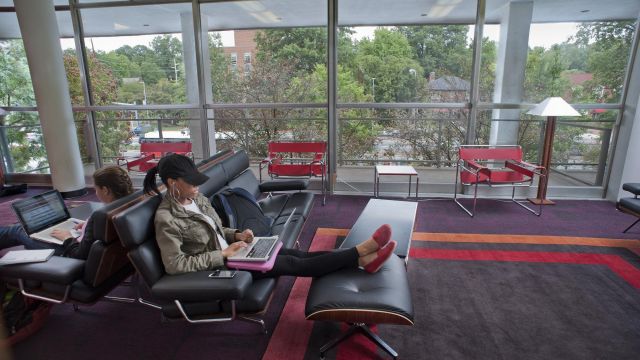 Students enjoy lounging on padded chairs and ottomans in the D H Hill Junior living room that overlooks Hillsborough Street.