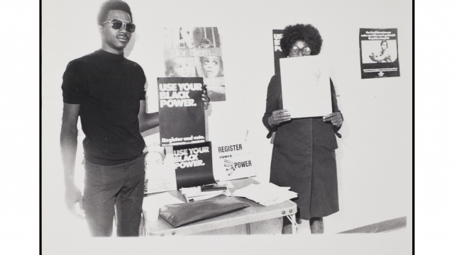 Two Chicago Urban League members holding posters up, reading, “Use Your Black Power”.