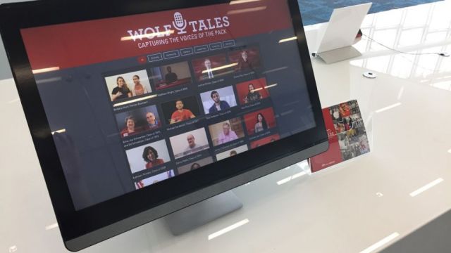 Computer monitor displaying a grid of faces of Wolf Tales interviewees