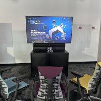 Console gaming station with large screen and three chairs