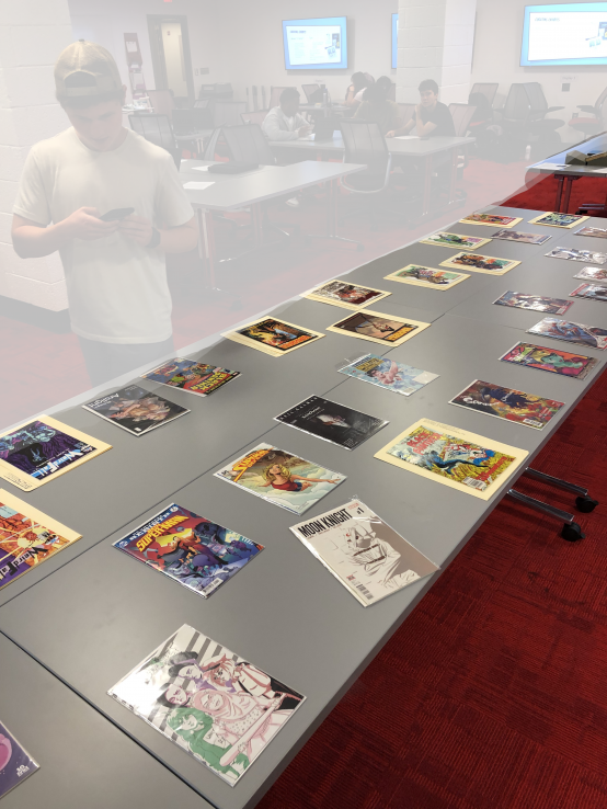 Comic books displayed on a table for students to examine.