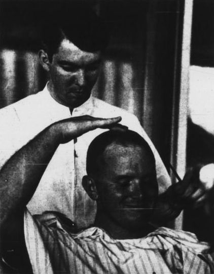 Student Gene Dees getting a hair cut during "Fleece for Peace."